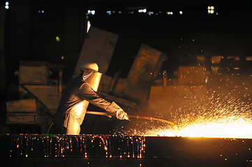 Image showing worker using torch cutter to cut through metal 