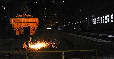 Image showing worker using torch cutter to cut through metal