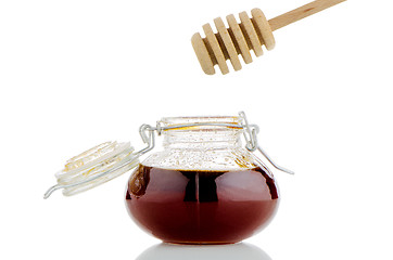 Image showing Jar of honey with wooden drizzler