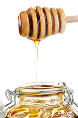 Image showing Jar of honey with wooden drizzler