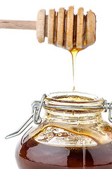 Image showing Jar of honey with wooden drizzler