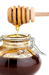 Image showing Jar of honey with wooden drizzler