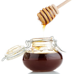 Image showing Jar of honey with wooden drizzler