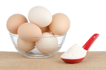 Image showing Brown eggs on brown and red ceramic spoon with white powder