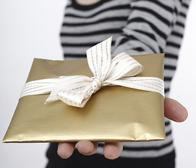 Image showing Young woman holding a present