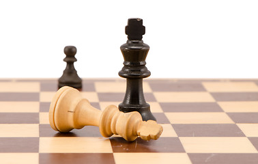 Image showing white chess king lie near winner black legs 