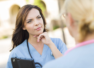 Image showing Two Young Adult Female Doctors or Nurses Talking Outside