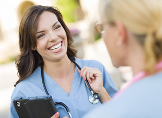 Image showing Two Young Adult Female Doctors or Nurses Talking Outside