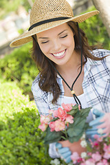 Image showing Young Adult Woman Wearing Hat Gardening Outdoors