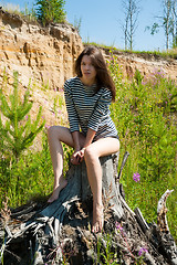 Image showing portrait of young beautiful woman on stump