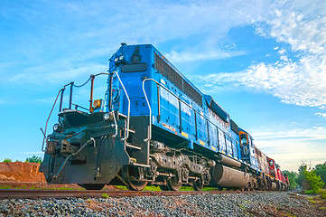 Image showing blue freight train engine at sunrise 