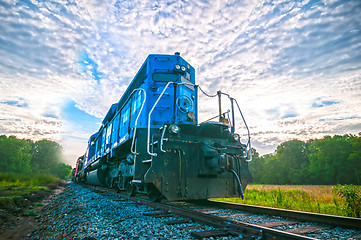 Image showing blue freight train engine at sunrise 