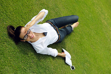 Image showing Young woman reading a book in the park