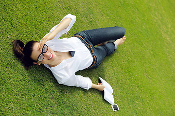 Image showing Young woman reading a book in the park