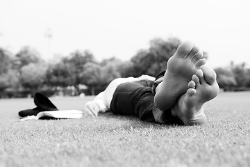 Image showing Young woman reading a book in the park