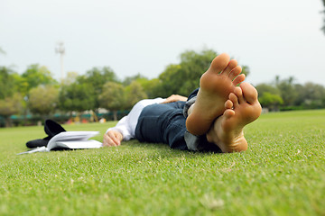 Image showing Young woman reading a book in the park