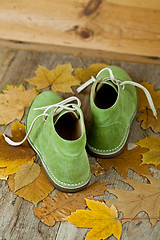 Image showing pair of green leather boots and yellow leaves 