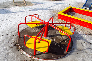Image showing carousel with yellow chairs and red rails winter 