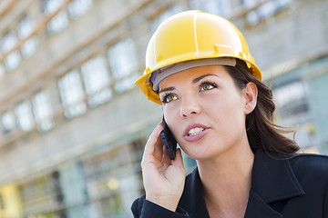 Image showing Young Female Contractor Wearing Hard Hat on Site Using Phone