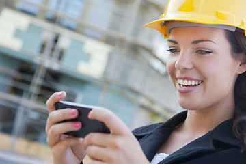 Image showing Female Contractor Wearing Hard Hat on Site Texting with Phone