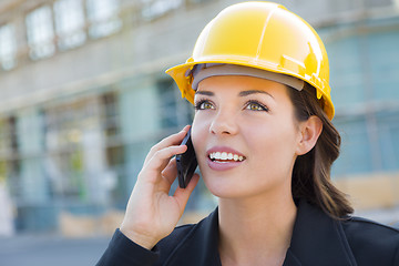 Image showing Young Female Contractor Wearing Hard Hat on Site Using Phone