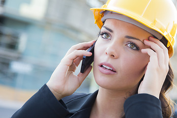 Image showing Worried Female Contractor Wearing Hard Hat on Site Using Phone