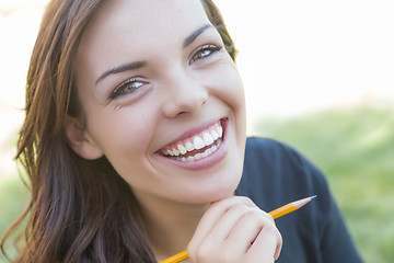 Image showing Portrait of Pretty Young Female Student with Pencil on Campus