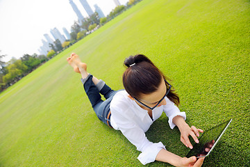 Image showing Beautiful young woman with  tablet in park