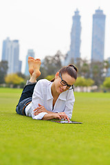 Image showing Beautiful young woman with  tablet in park