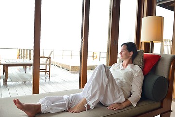 Image showing happy young woman relax at home on sofa