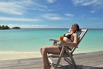 Image showing Beautiful young woman with a drink by the sea