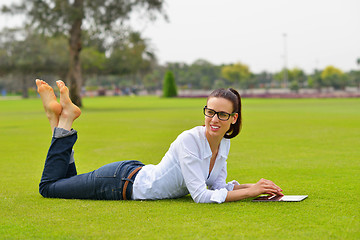 Image showing Beautiful young woman with  tablet in park