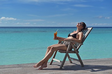 Image showing Beautiful young woman with a drink by the sea