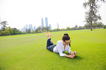 Image showing Beautiful young woman with  tablet in park