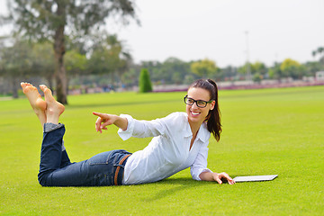 Image showing Beautiful young woman with  tablet in park