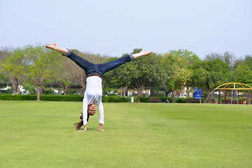 Image showing young woman jumping in park