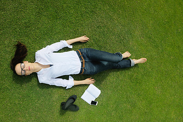 Image showing Young woman reading a book in the park