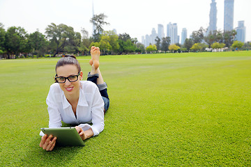 Image showing Beautiful young woman with  tablet in park