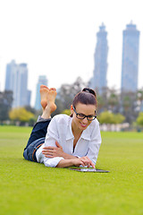 Image showing Beautiful young woman with  tablet in park