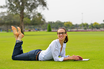 Image showing Beautiful young woman with  tablet in park