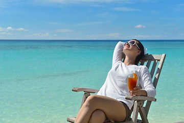 Image showing Beautiful young woman with a drink by the sea