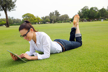 Image showing Beautiful young woman with  tablet in park