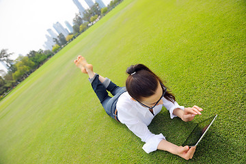 Image showing Beautiful young woman with  tablet in park