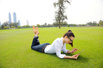 Image showing Beautiful young woman with  tablet in park