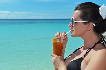 Image showing Beautiful young woman with a drink by the sea