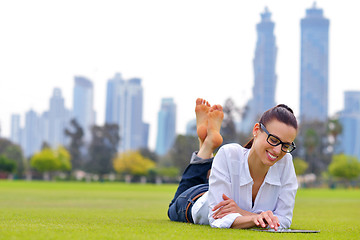 Image showing Beautiful young woman with  tablet in park