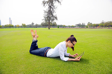 Image showing Beautiful young woman with  tablet in park