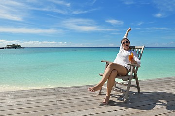 Image showing Beautiful young woman with a drink by the sea