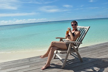 Image showing Beautiful young woman with a drink by the sea