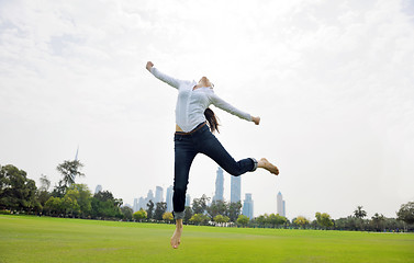 Image showing young woman jumping in park